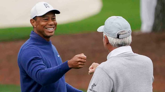 Tiger Woods gives Fred Couples a fist bump during a 2023 Masters practice round.